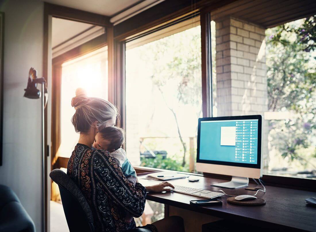mom-holding-baby-while-on-computer