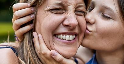 daughter-kissing-mother-on-cheek