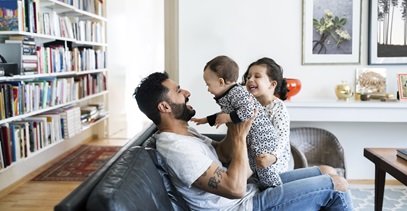 dad sitting on couch with two toddlers