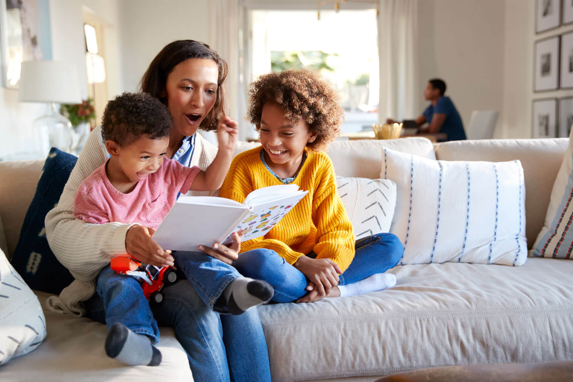 Family sitting on a couch and reading.