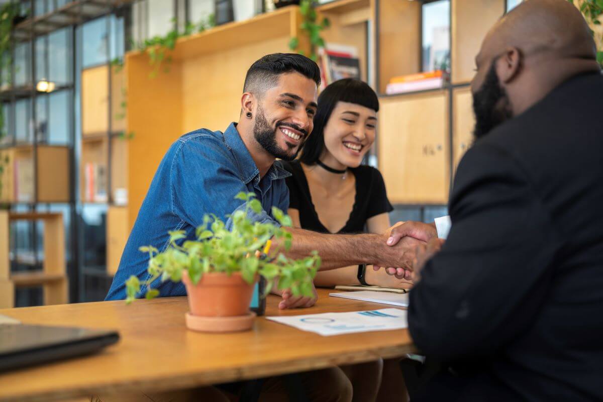 young-couple-shaking-hands-with-advisor