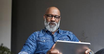 Image of a man searching online with a tablet device